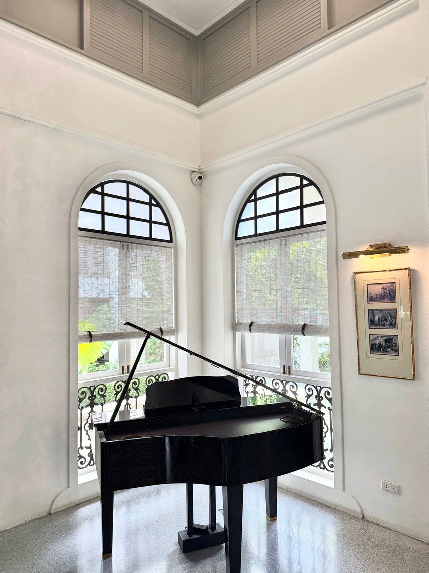 Styled still, piano by arched windows